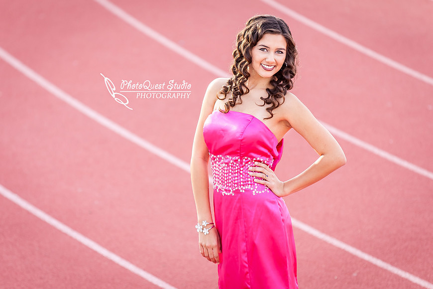 High School Senior photos session of beautiful Latina Teen from Menifee, California - Miss Isabel Donadio.  Location: Paloma Valley High School, Menifee, CA.  Photography: PhotoQuest Studio - Menifee Wedding, Family and Event Photographer, cute smiling on the track