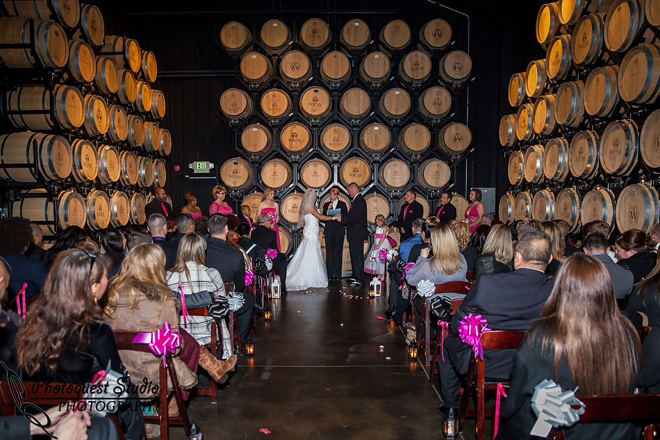 wedding ceremoy in the barrel room at Wiens family cellars temecula winery by temcula wedding photographer