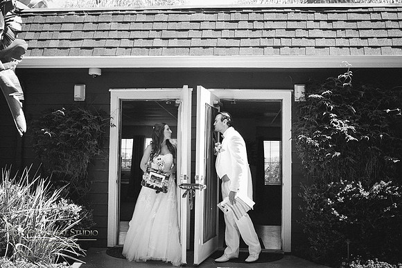 bride and groom kissing each other behind the door by temecula wedding photographer