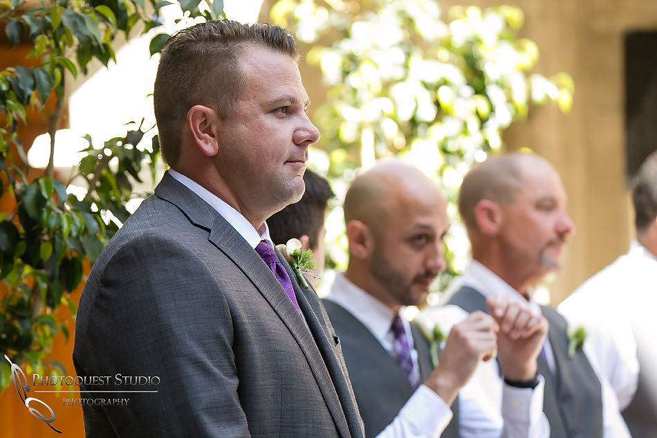 Groom watching the bride entering the wedding with her brother crying