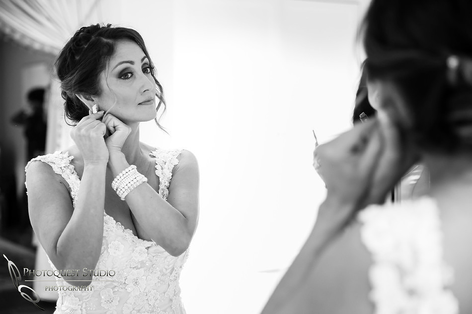 Bride putting on her earing by Temecula Wedding Photographer