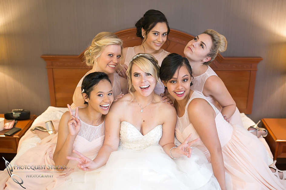 Bride and Bridesmaids being funny on the bed by Temecula, Fallbrook wedding photographer