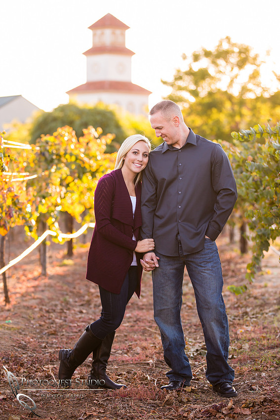 Looking at her in vineyard at Engagement photo at South Coast Winery, California by Temecula Wedding Photographers