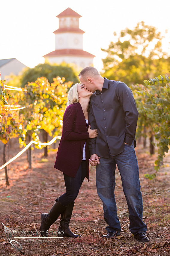 Kissing in front of the vineyard at Engagement photo at South Coast Winery, California by Temecula Wedding Photographers
