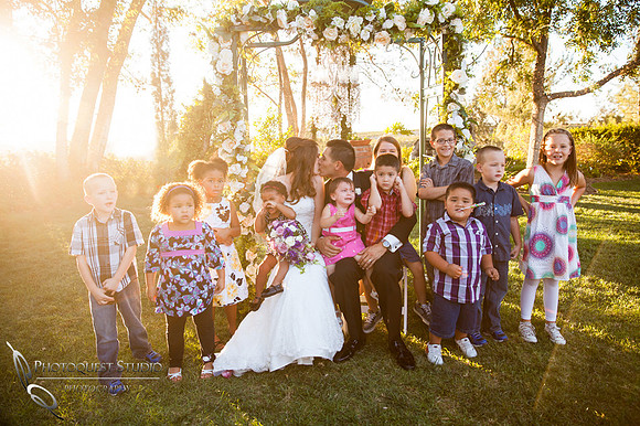 bride and groom kiss while kids are crying at Falkner winery wine wedding by temecula wedding photographer