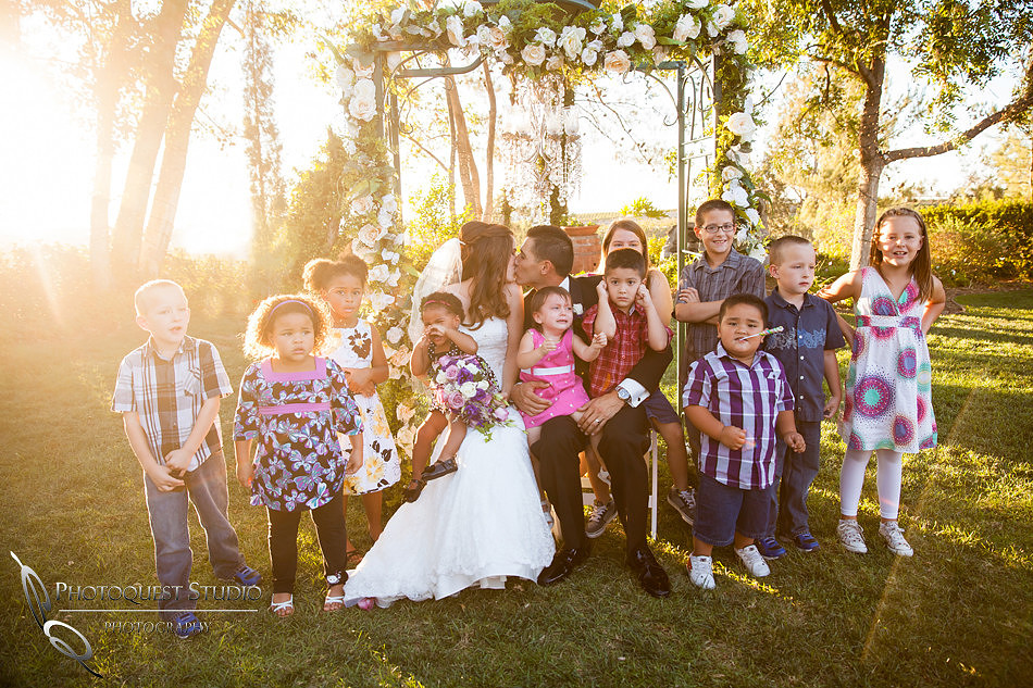bride and groom kiss while kids are crying at Falkner winery wine wedding by temecula wedding photographer